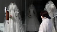 웨딩샵 앞을 지나가는 여성