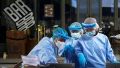 เจ้าหน้าที่สาธารณสุขตั้งโต๊ะเก็บตัวอย่างตรวจหาโควิดที่หน้าสถานบันเทิงย่านทองหล่อ