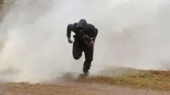 Мигрант бежит от водомета