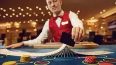 Un crupierbetesporte comercialun casino barajando cartas.