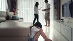 Casal brigando com criança triste em primeiro plano