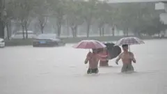 Zhengzhou kentinde insanlar sel sularında