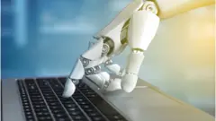 የሮቦት እጅ በኮምፒውተር ኪቦርድ ላይ