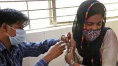 ਟੀਕਾ ਲਗਵਾਉਂਦੀ ਕੁੜੀ