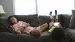 Two kids sitting on the sofa