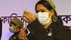 কুর্মিটোলা জেনারেল হাসপাতালে একজন স্বাস্থ্যকর্মী টিকা দেবার কাজ করছেন - ২৭শে জানুয়ারি ২০২১