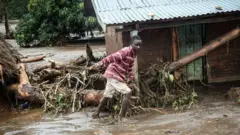A boy walks through the mud after a river burst its bank West Pokot county, western Kenya on November 24, 2019