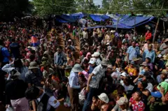 TOPSHOT - People who fled their homes near the border between Cambodia and Thailand gather at a food distribution site on the grounds of a pagoda in Oddar Meanchey province on July 28, 2025. Thailand and Cambodia will enter into an unconditional ceasefire starting at midnight on July 28, Malaysia's Prime Minister Anwar Ibrahim announced. (Photo by TANG CHHIN Sothy / AFP) (Photo by TANG CHHIN SOTHY/AFP via Getty Images)