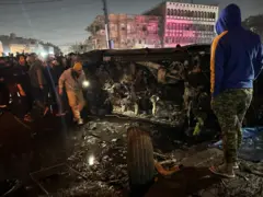 عراقيون يتجمعون حول موقع القصف الأمريكي الذي استهدف سيارة تابعة لقادة الفصائل العراقية الموالية لإيران