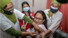 ঢাকা মেডিকেল কলেজ হাসপাতালে ভ্যাকসিন নিচ্ছেন একজন স্বাস্থ্যকর্মী