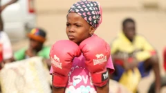 A girl in pink boxing gloves in Lagos, Nigeria - Saturday 5 March 2022
