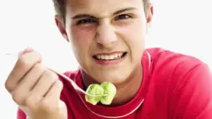 صبي يأكل الخضراوات ممتعضا