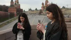 इंटरनेट एक्सेस करने की कोशिश करतीं क्रेमलिन के क़रीब खड़ी महिलाएं (सांकेतिक तस्वीर)