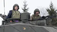 Liz Truss chụp ảnh trên xe tăng khi thăm lính Anh tại Estonia năm ngoái.