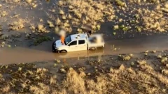 Aerial shot of the father and son sitting on top of their stranded vehicle