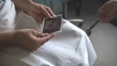 Žena gleda sliku sa ultrazvuka