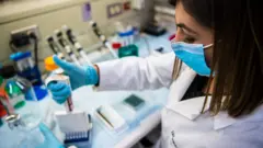 Лаборант проводит эксперимент с вакциной от рака груди