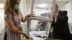 موظفو الانتخابات يفرغون صناديق الاقتراع