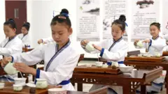 Niñas asiáticas practican el ritual del té