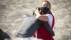 Una ayudante médica atendiendo a un migrante en la zona de Ceuta el 18 de mayo de 2021.