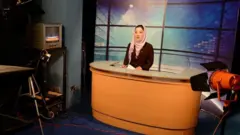 2013 yılında Afganistan'ın başkenti Kâbil'de bir kadın televizyon sunucusu stüdyoda görülüyor