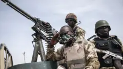 Three soldiers wey siddon on top tanker.