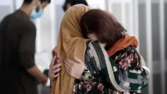 Umugore ahobera muramukazi we ubwo yari ageze muri Amerika hamwe n'izindi mpunzi bavuye muri Afghanistan