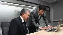 Ноутбукка қараётган Президент Мирзиёев