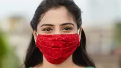 మాస్క్ ధరించిన యువతి