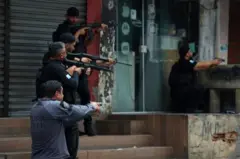 Policiais com armas nas mãos durante operação