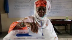 A woman casts her ballot a polling office during the presidential election in Abidjan, Ivory Coast, 31 October, 2020.