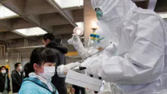 Un funcionario cubierto en un traje de protección nuclear mide los niveles de radiación en una niña