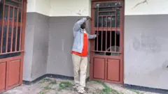 Kitsa Floribert, le directeur de l'EP Kalembo, devant la porte de son bureau fermé