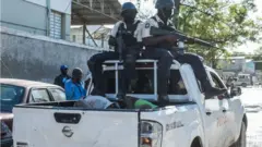 Police in a truck with some recaptured prisoners