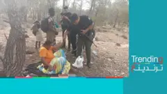 صور لعناصر من الحرس التونسي أثناء إسعافهم لمهاجرة من دول جنوب صحراء إثر ولادتها في غابة بالقرب من الحدود الجزائرية.