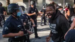Un manifestante confronta a policías