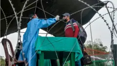 ফুলবাড়ী সীমান্তে একজন যাত্রীকে পরীক্ষা করা হচ্ছে