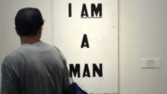 man looking at painting