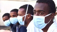 ጭምብል ያጠለቁ ወጣቶች