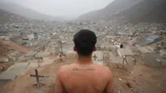 Sepulturero mira hacia un cementerio en las afueras de Lima, Perú.