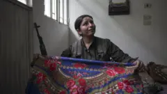 دختر نوزده ساله کرد درحال آماده شدن جهت ورود به میدان نبرد در جبهه شرقی شهر. نوامبر ۲۰۱۴