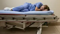 A nurse taking a nap in a stretcher