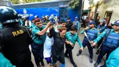 Police escort detainees accused of allegedly plotting the Holey Artisan Bakery cafe attack