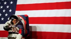 Advanced Space Suit Engineer Kristine Davis wears the xEMU prototype space suit during its presentation at NASA headquarters