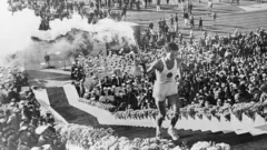 Atleta carrega tocha olímpica na abertura das Olimpíadas de Tóquio de 1964