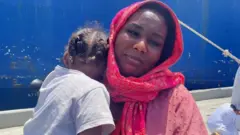 Evacuada sudanesa Rasha con su hijo pequeño.