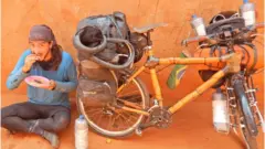 Ricardo Martins, na Tanzânia, ao lado de bicicleta de bambu usada para fazer jornada por diversos países