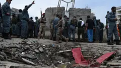 Afghan security personnel stand at the scene of a suicide attack by Taliban militants on the Afghan parliament building in Kabul on June 22, 2015.