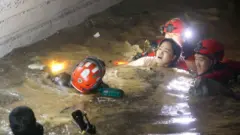 Firefighters and military officials rescue one of the missing residents