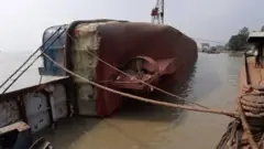 নদীতে কাত হয়ে থাকা ফেরি আমানত শাহ